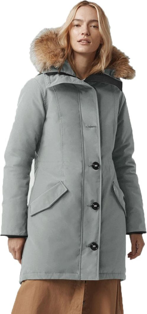 A woman wearing a gray parka with fur trim.