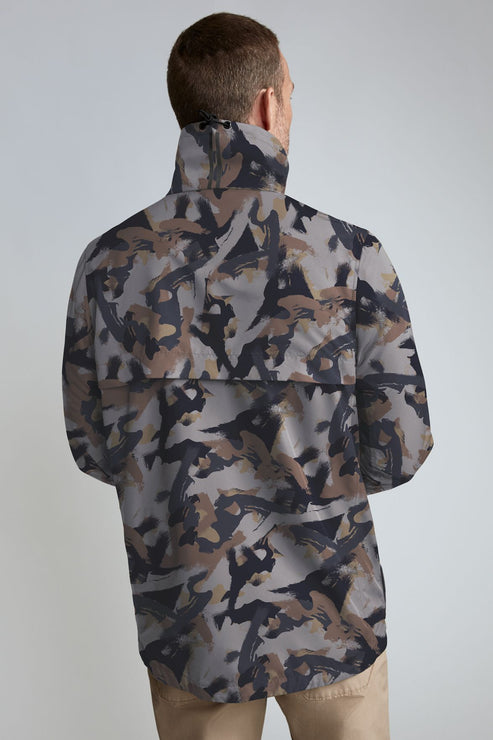 Man wearing a camouflage print collared shirt with a pocket across the back.