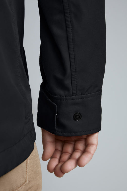 Close-up of a black jacket cuff with a button and a hand.