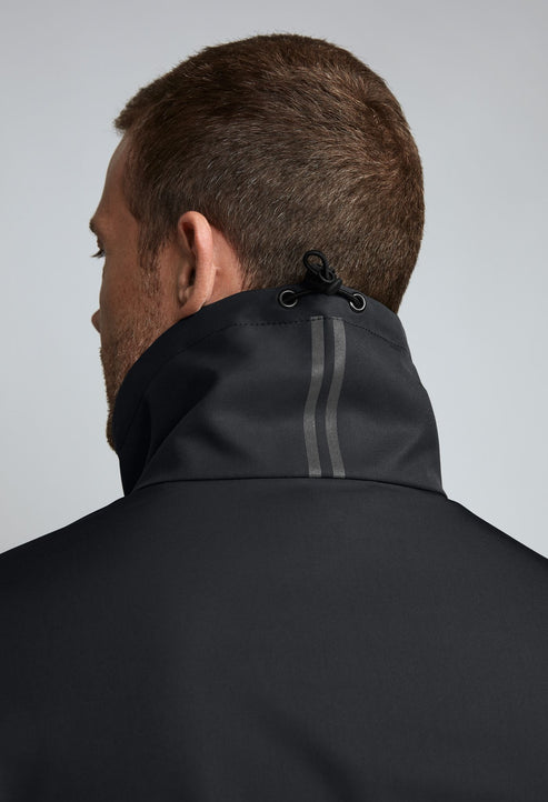 Close-up of a man's back wearing a black jacket with a high collar and a drawstring.