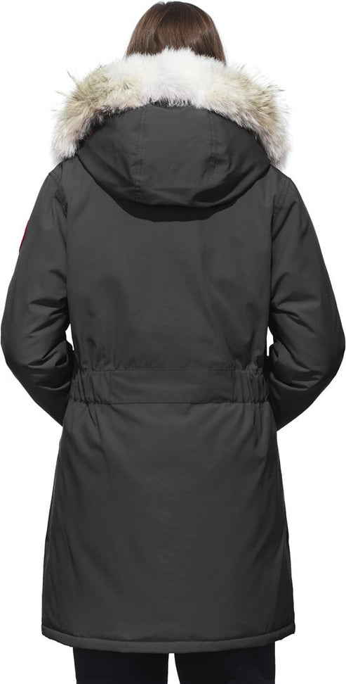 A woman wearing a black hooded winter coat with a white fur trim.