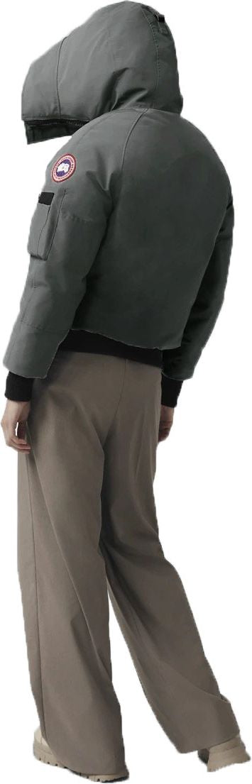 A person is wearing a gray jacket with a hood and beige pants.