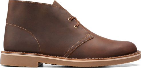 A brown leather chukka boot with laces.