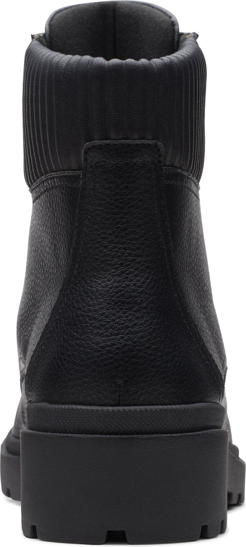 Rear view of a black boot with a knit collar and block heel.