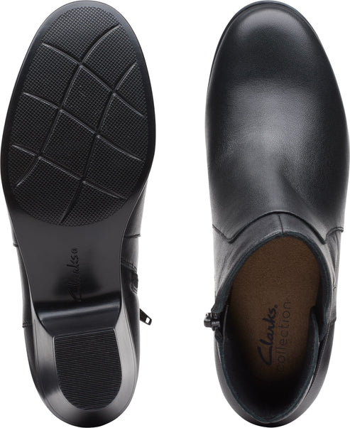 Two views of a black, leather, heeled ankle boot with a side zip and rubber sole. One shows the sole, the other shows the inside of the boot.
