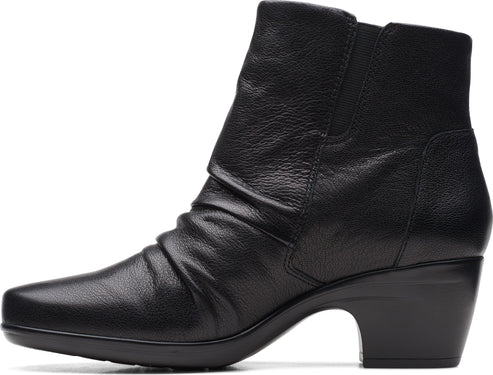 A black leather ankle boot with a short stacked heel, almond toe and gathered details.