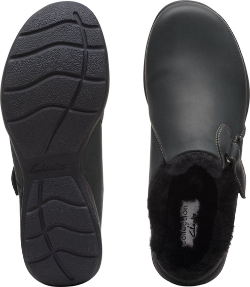 Two black slip-on shoes, one showing the sole and the other showing a furry interior.