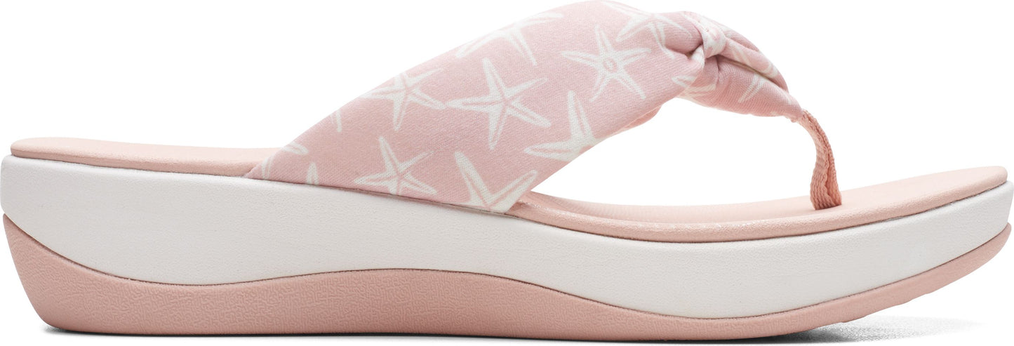 A pink flip-flop sandal with white starfish print and a thick white sole.