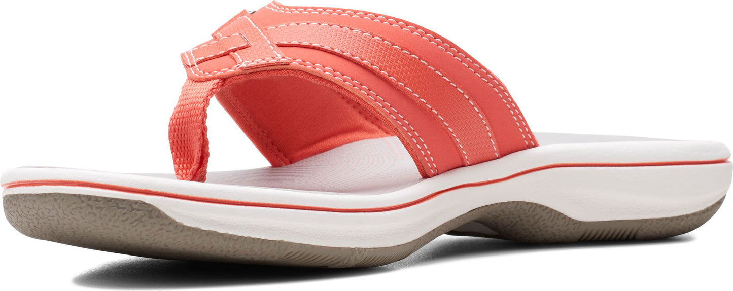 A coral-colored sandal featuring a toe post and padded upper.