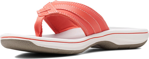 A coral-colored sandal featuring a toe post and padded upper.