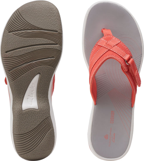 Pair of flip flops: top-down view reveals a gray insole with coral straps. The sole has wave-like treads and a white and brown heel.
