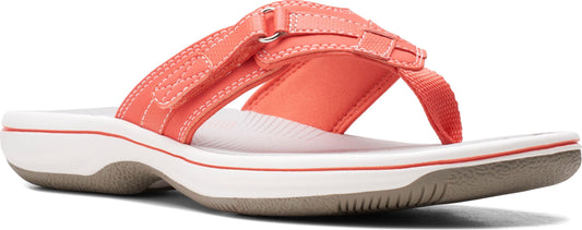 A coral sandal with white soles.