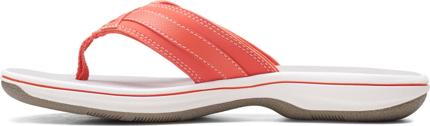 A coral flip-flop with a white and brown sole.
