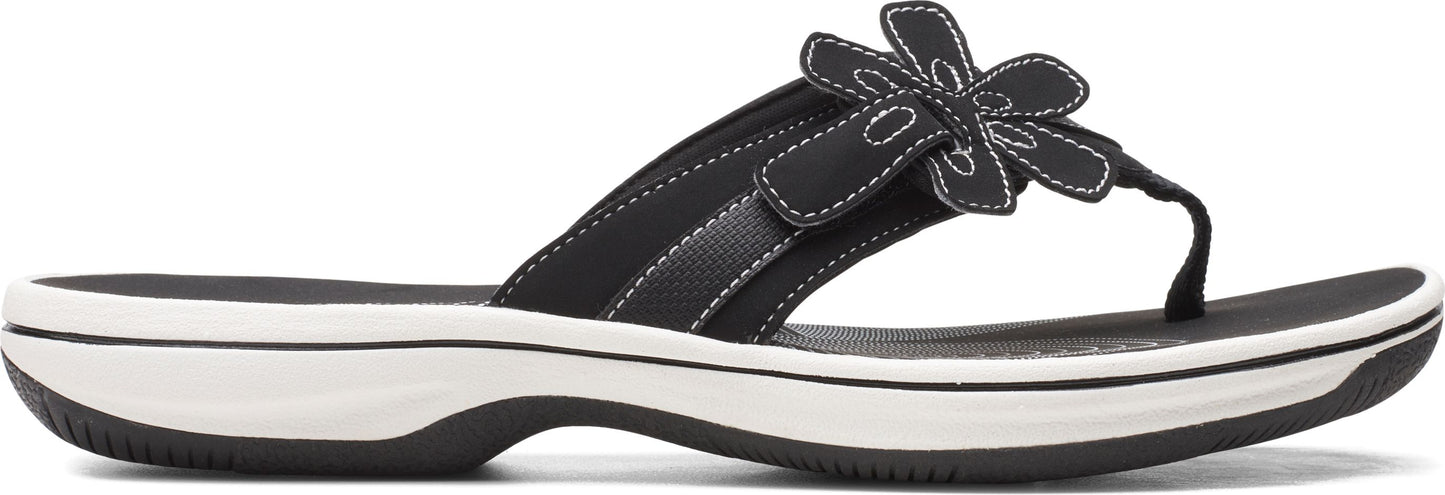 A women's black sandal with a flower on the strap.