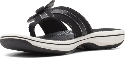 A black sandal with a flower-like decoration.