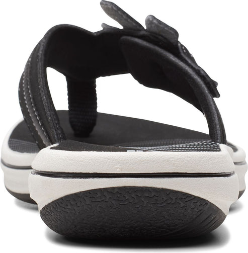 Rear view of a black and white thong sandal with a thick sole and a black strap.