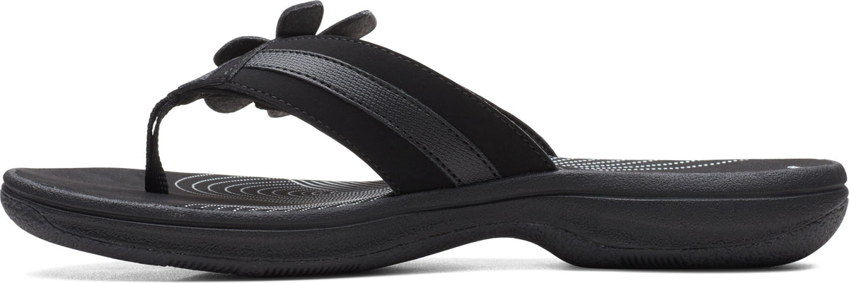 A black sandal with flower decoration.