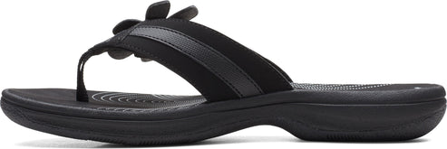 A black sandal with flower decoration.