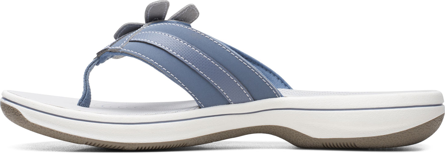 A blue sandal with a flower on top.