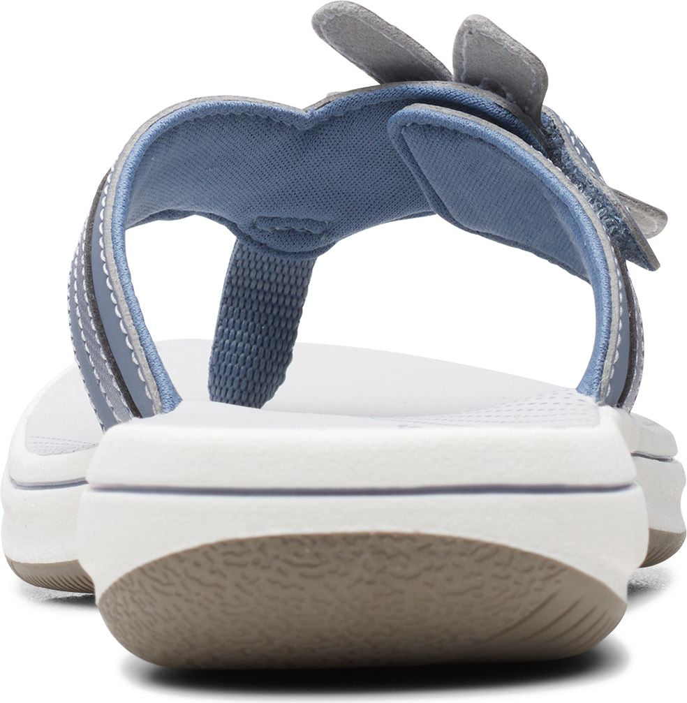 Back view of a light blue sandal with a gray flower accent on the strap and a white sole.