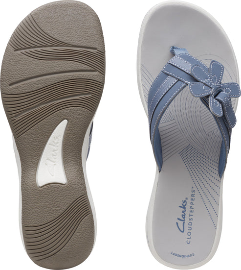 Light blue flip flops showing the textured sole and the insole featuring a flower design.