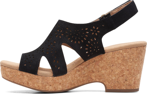 Black wedge sandal with cut-out pattern and cork sole.