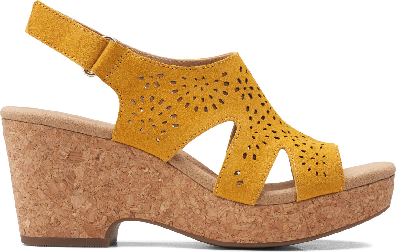 Mustard yellow wedge sandal with cork heel and laser-cut flower details.
