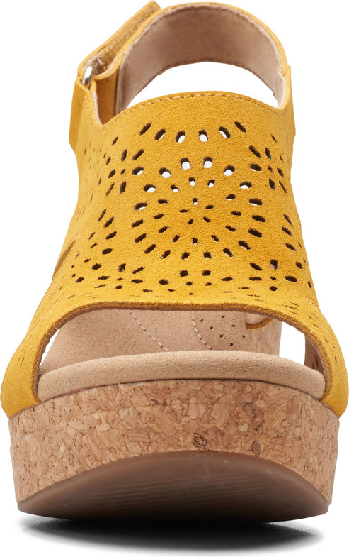 Eye-level view of yellow open-toed platform sandals featuring laser-cut designs and a cork wedge heel.