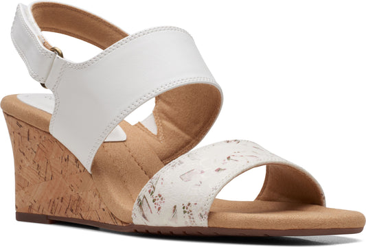 White wedge sandal with ankle strap and floral patterned toe strap.