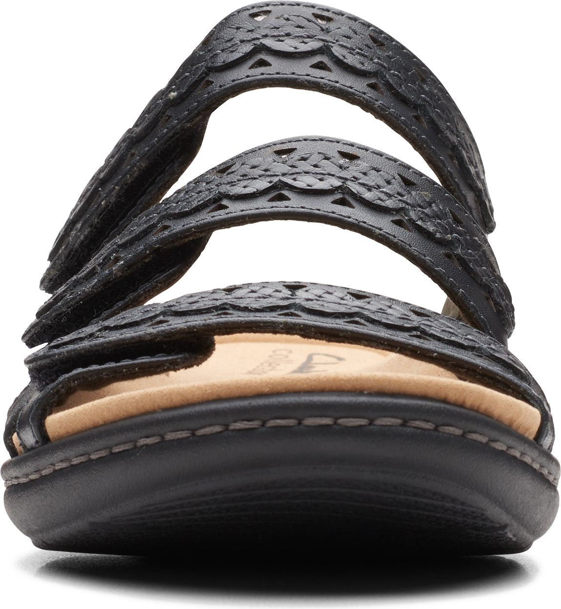 Close-up of black sandal with decorative cutouts on straps and a light tan insole.