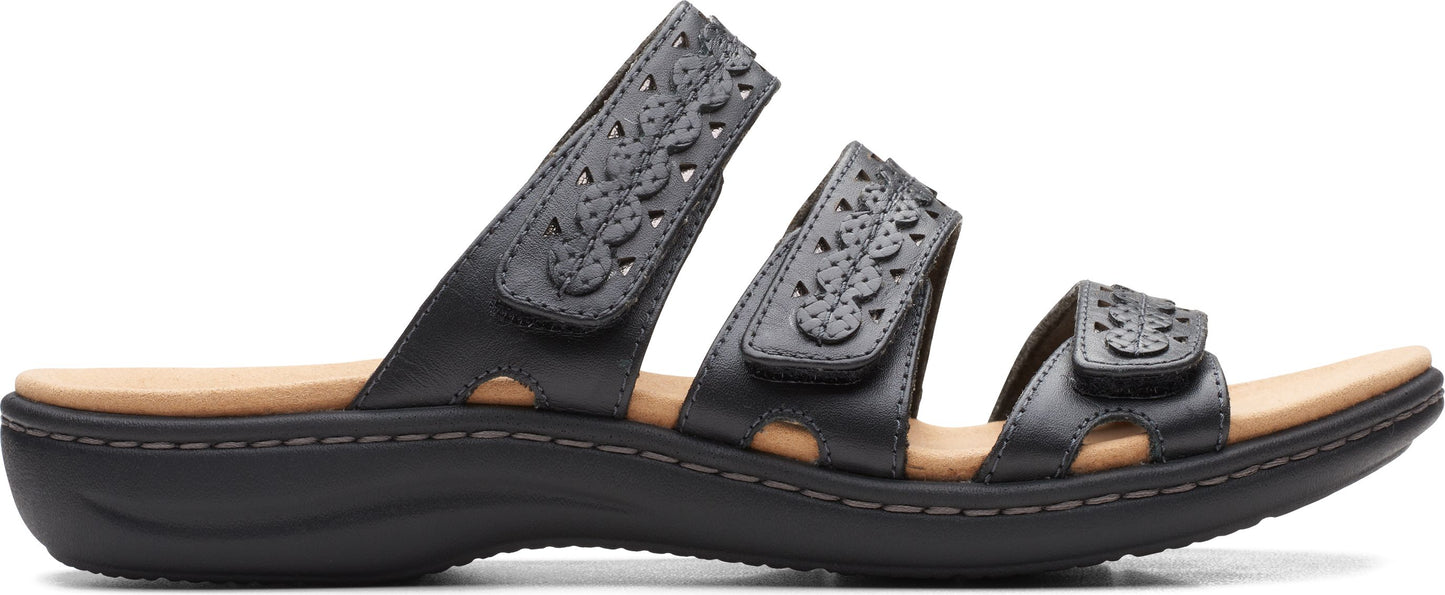 Black sandal with three straps, each decorated with flower cutouts.