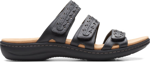 Black sandal with three straps, each decorated with flower cutouts.