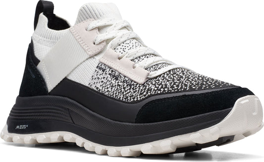 Low-top sneaker with black and white patterned upper, black suede accents, white laces, and a thick black and white sole.