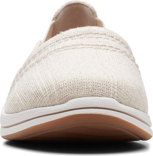 Close-up of a flax-colored slip-on shoe with white sole and tan bottom.
