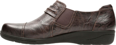 A brown leather slip-on shoe with a low wedge heel.
