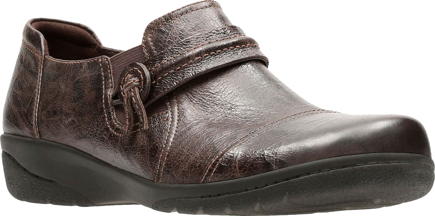 A brown leather shoe with a buckle-like strap.