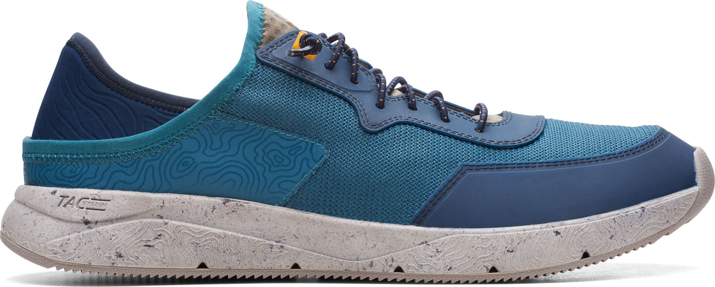 A blue slip on sneaker with a white sole and laces.