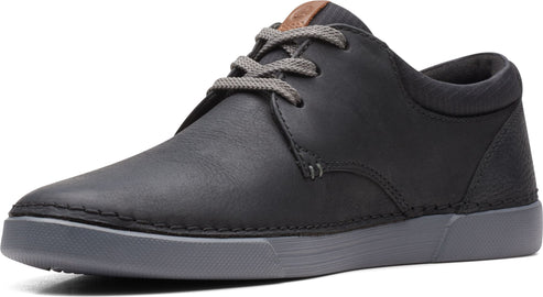 Black leather sneaker with gray laces and gray sole.