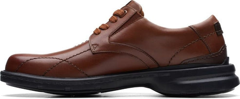 A brown leather dress shoe with a black sole.