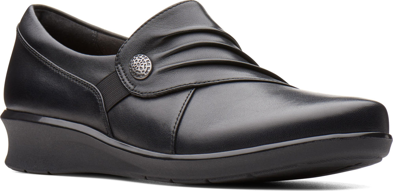 Black, rounded-toe, slip-on shoe with a low wedge heel and decorative button.