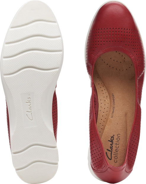 Top down view of a pair of red leather shoes. The left shoe shows the white treaded sole with logo. The right shoe shows the insole with "ULTIMATE COMFORT" and "collection" text.