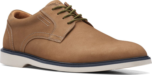 A tan dress shoe with green laces and a white sole.