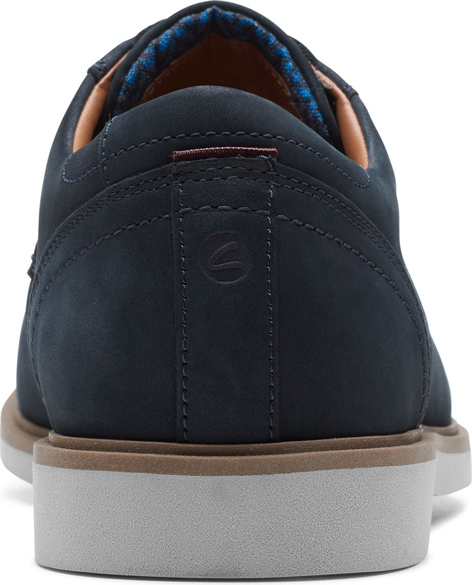 Back view of a navy blue leather shoe with a gray sole and patterned insole.