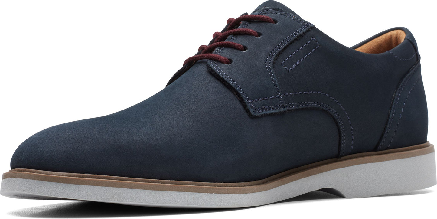 A blue leather dress shoe with brown laces and a white sole.