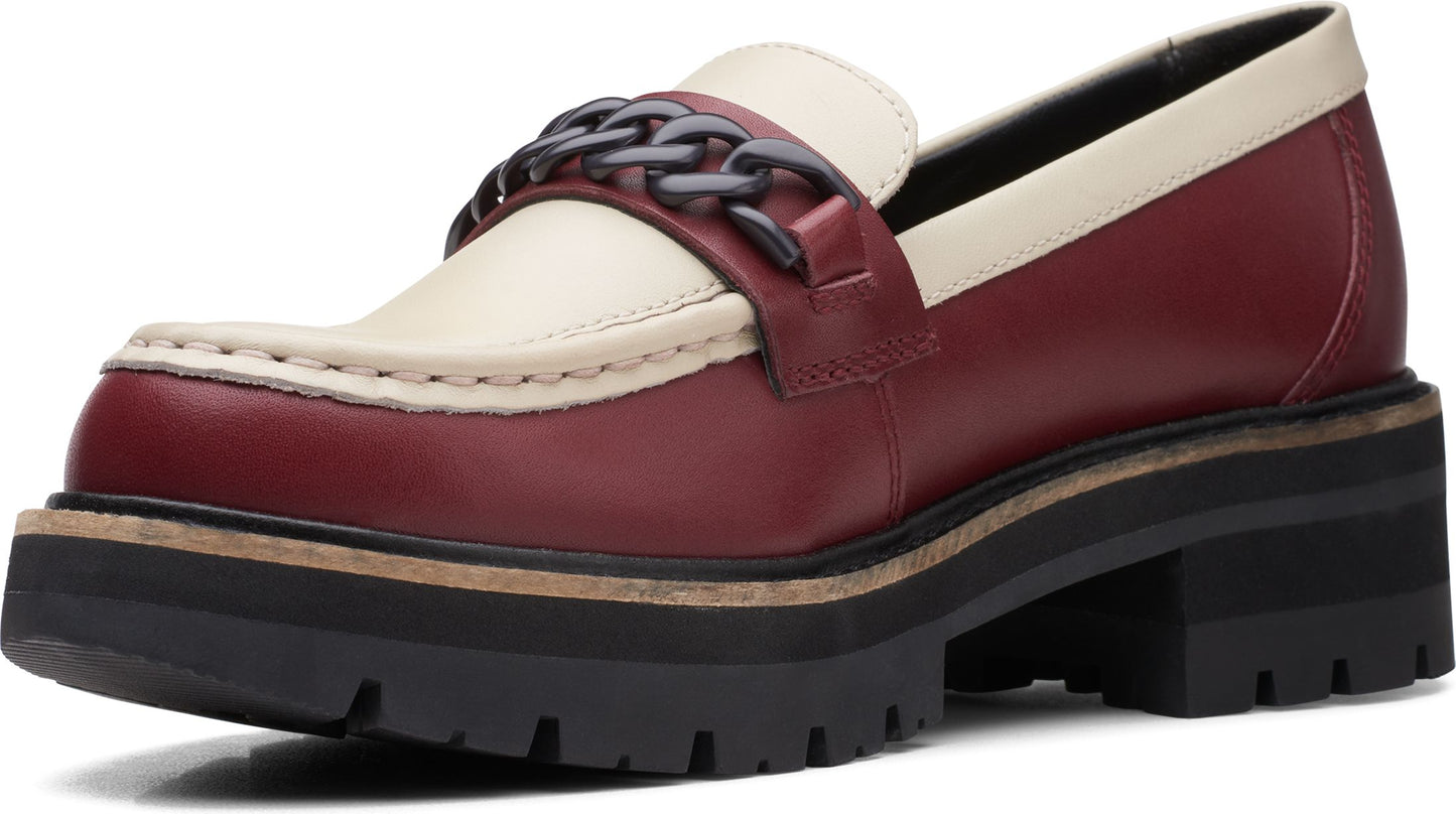 Two-toned burgundy and cream penny loafer with chunky black lug sole and a metal chain accent.