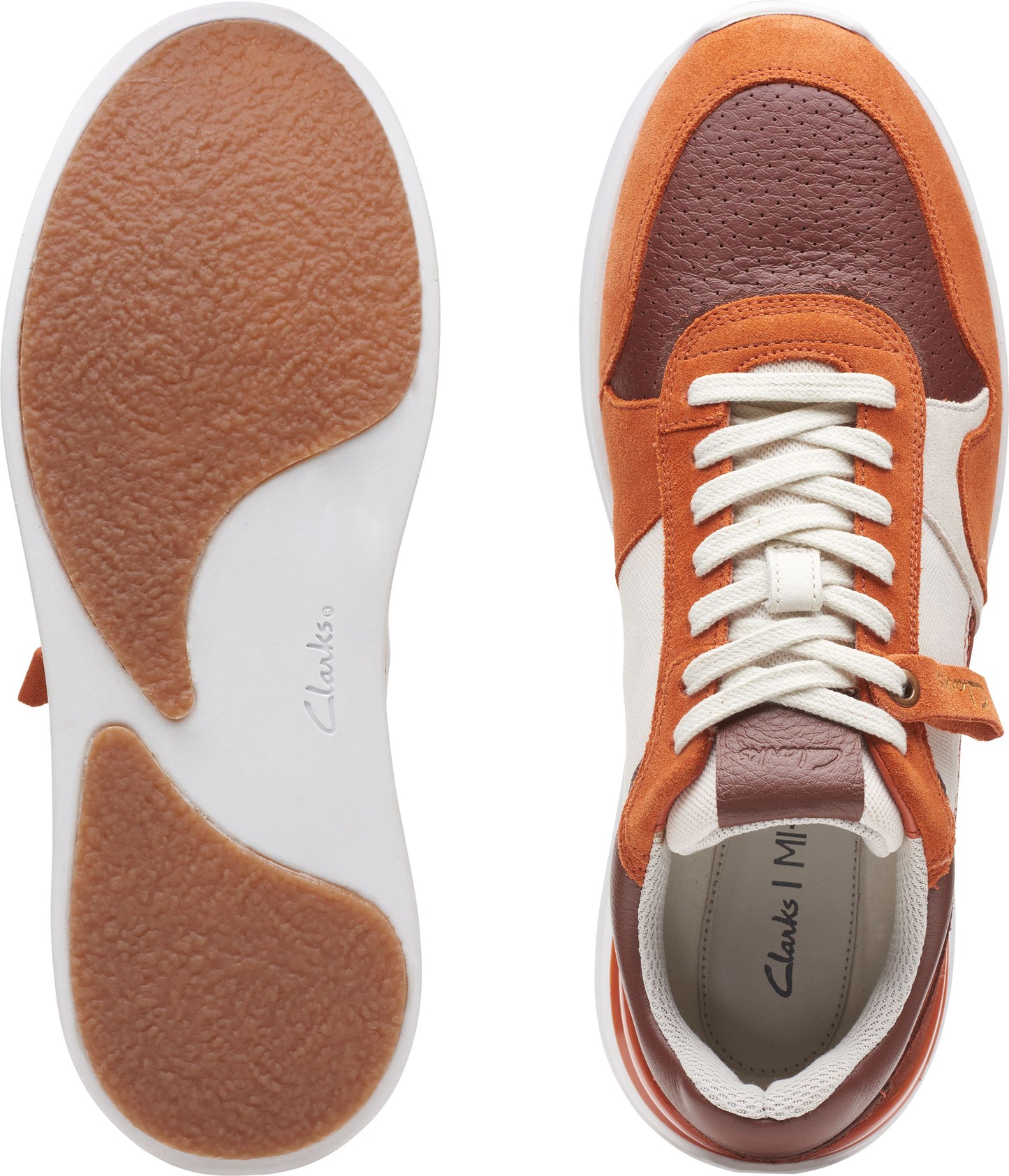 An overhead product shot displays the sole and upper portion of a multicolored sneaker. The sole is white and shows a section of the bottom as a light brown. The shoe is colored with off-white panels between brick red and orange suede panels, and white laces.