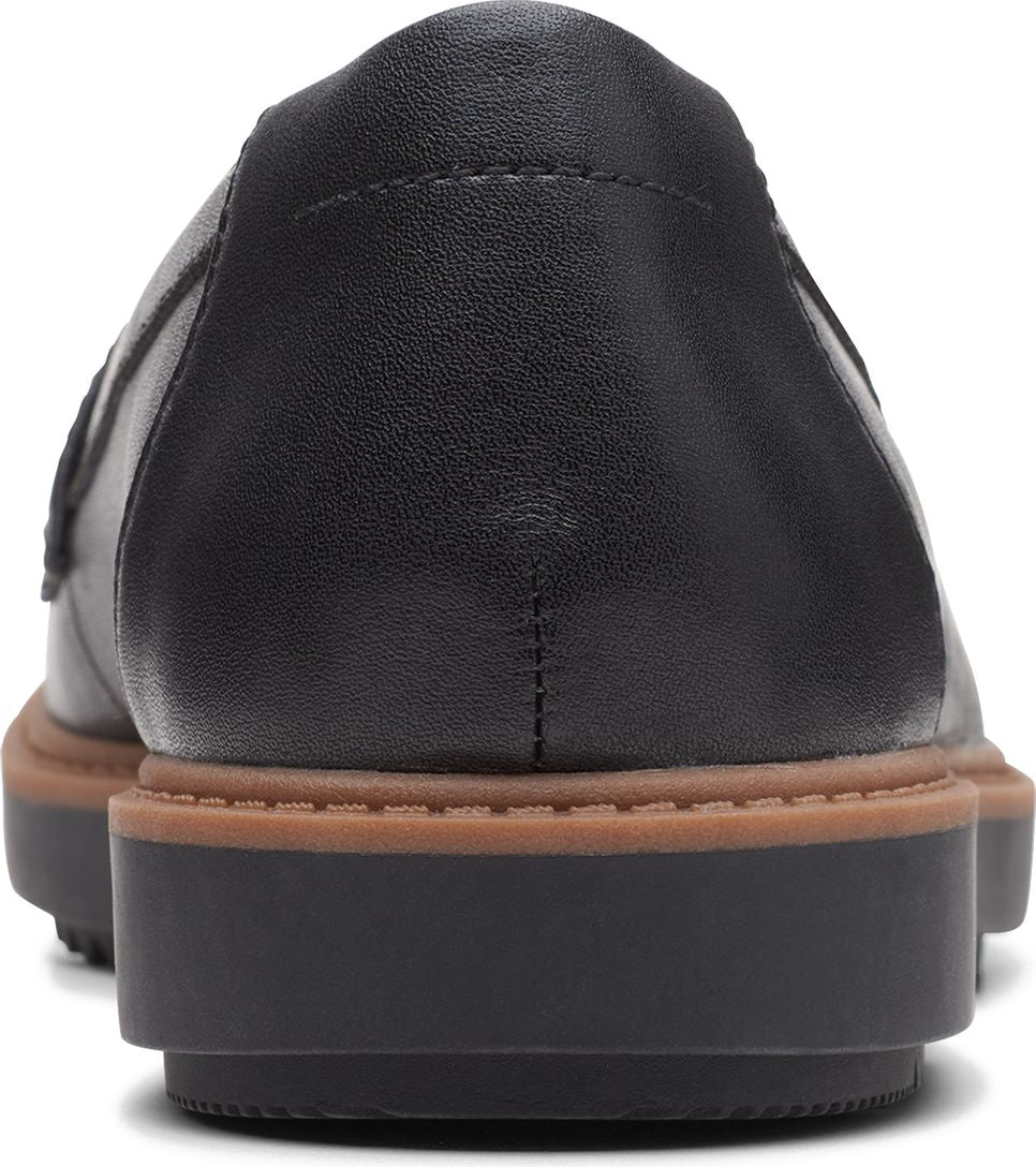 Close-up of a black leather loafer with brown mid-sole and black platform outsole.