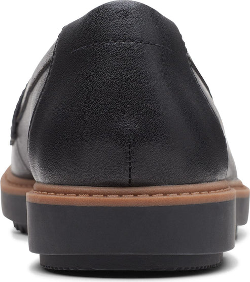 Close-up of a black leather loafer with brown mid-sole and black platform outsole.