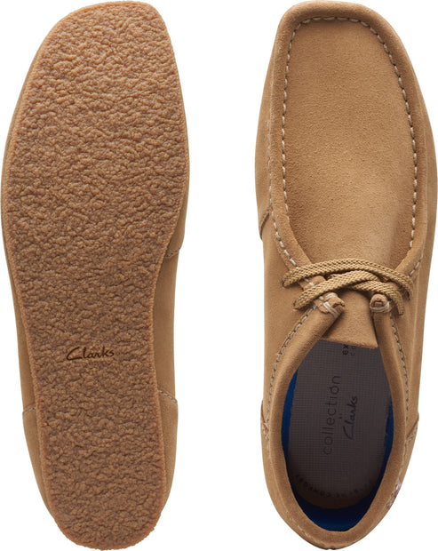 Two tan shoes: one upside down showing the textured sole and another with the top view showing laces and blue insole.