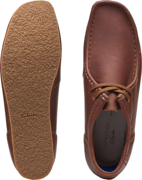 Pair of brown leather moccasin-style shoes, one sole-up showing textured outsole.